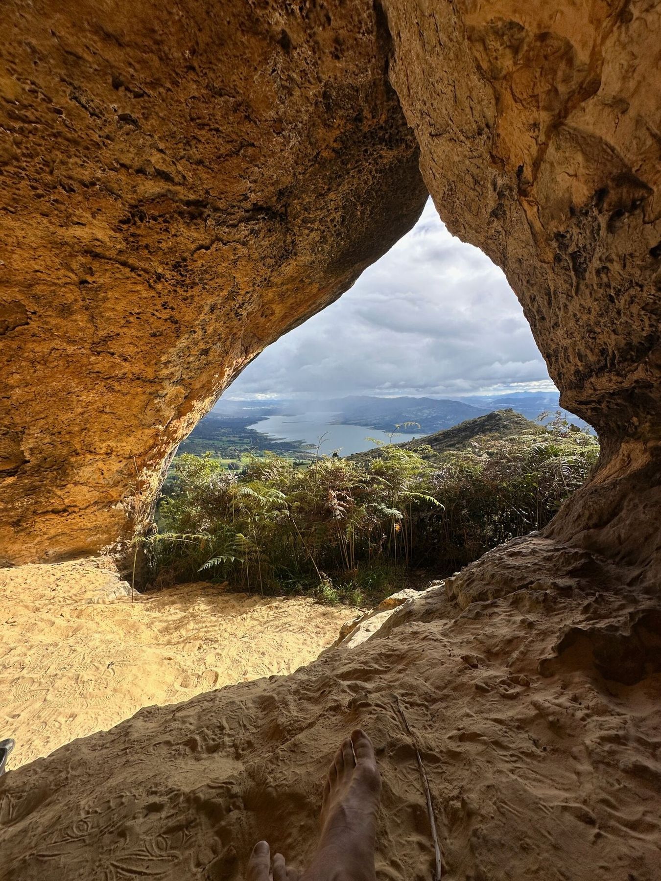 The opening of the sacred cave framing the lake and the valley